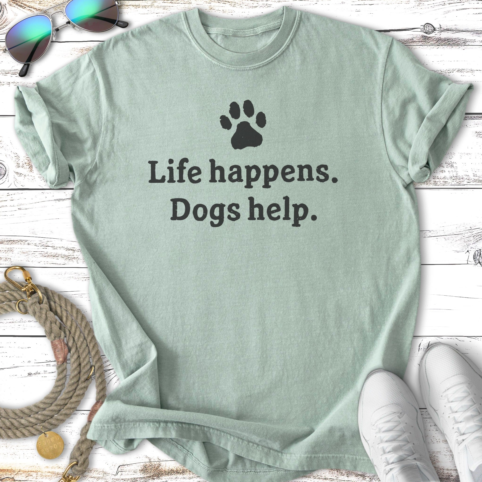 Light green t-shirt with "Life happens. Dogs help." and a paw print.
