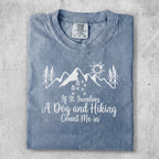Blue t-shirt with mountains, trees, sun graphic, and "If It Involves A Dog and Hiking Count Me in" text.