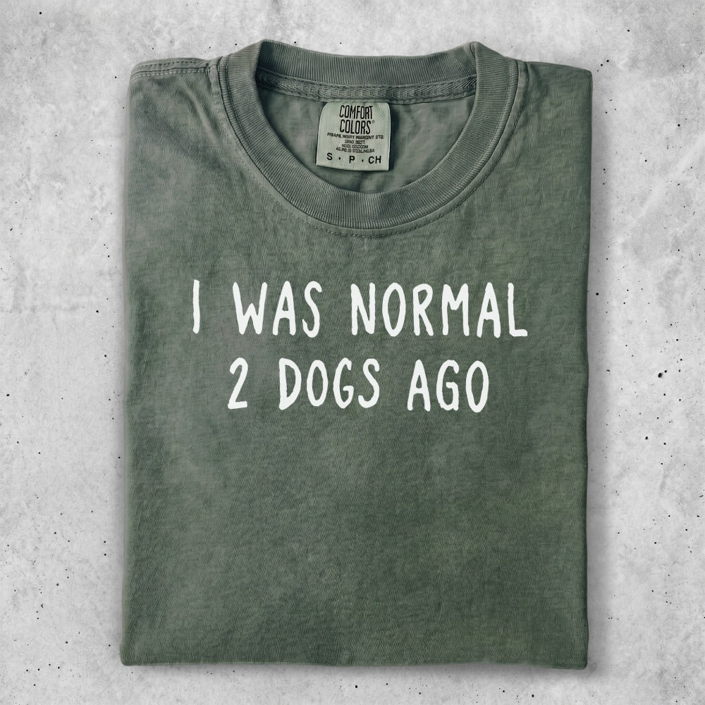 Green t-shirt with "I WAS NORMAL 2 DOGS AGO" text.