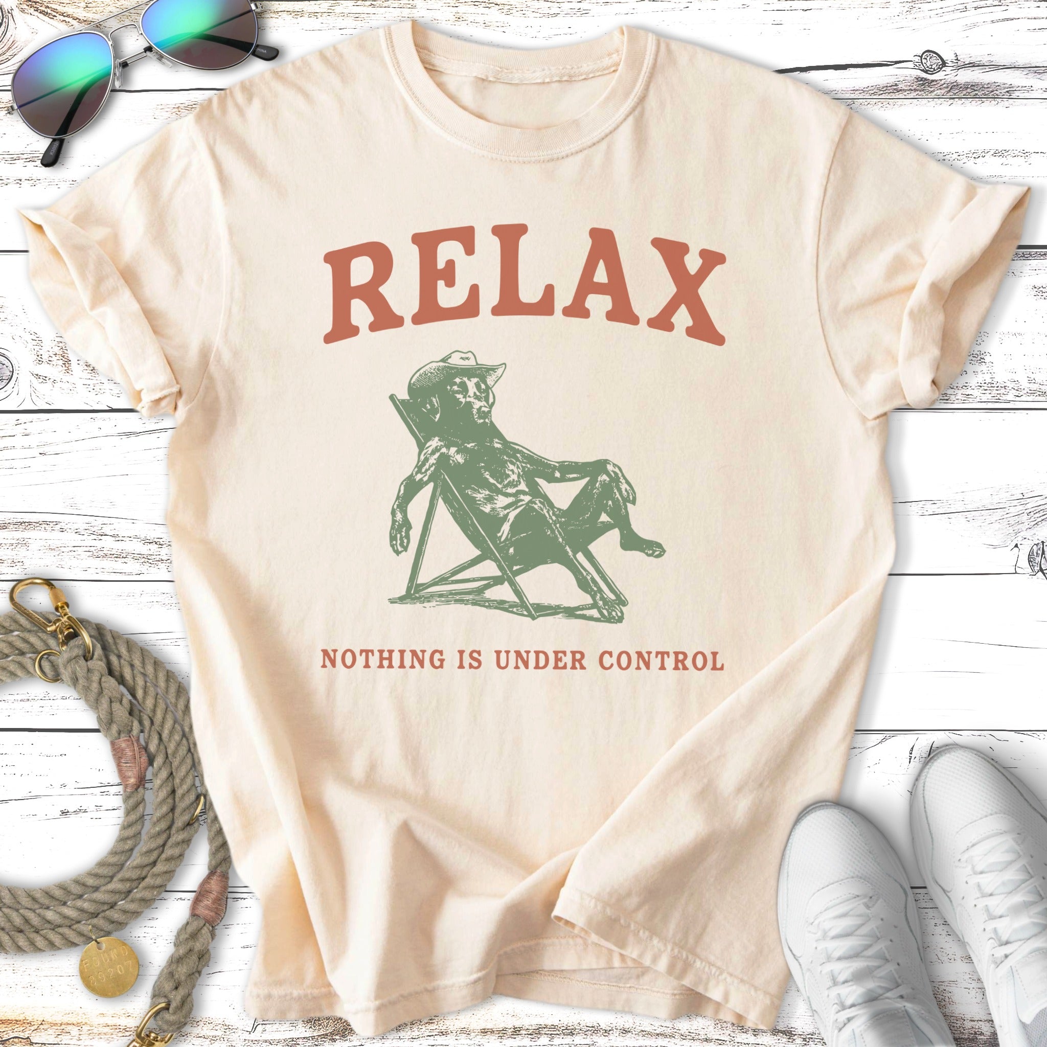 Cream t-shirt with "RELAX NOTHING IS UNDER CONTROL" text and illustration.