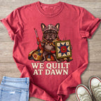 French bulldog in armor holding a seam ripper and a quilt, text "WE QUILT AT DAWN".