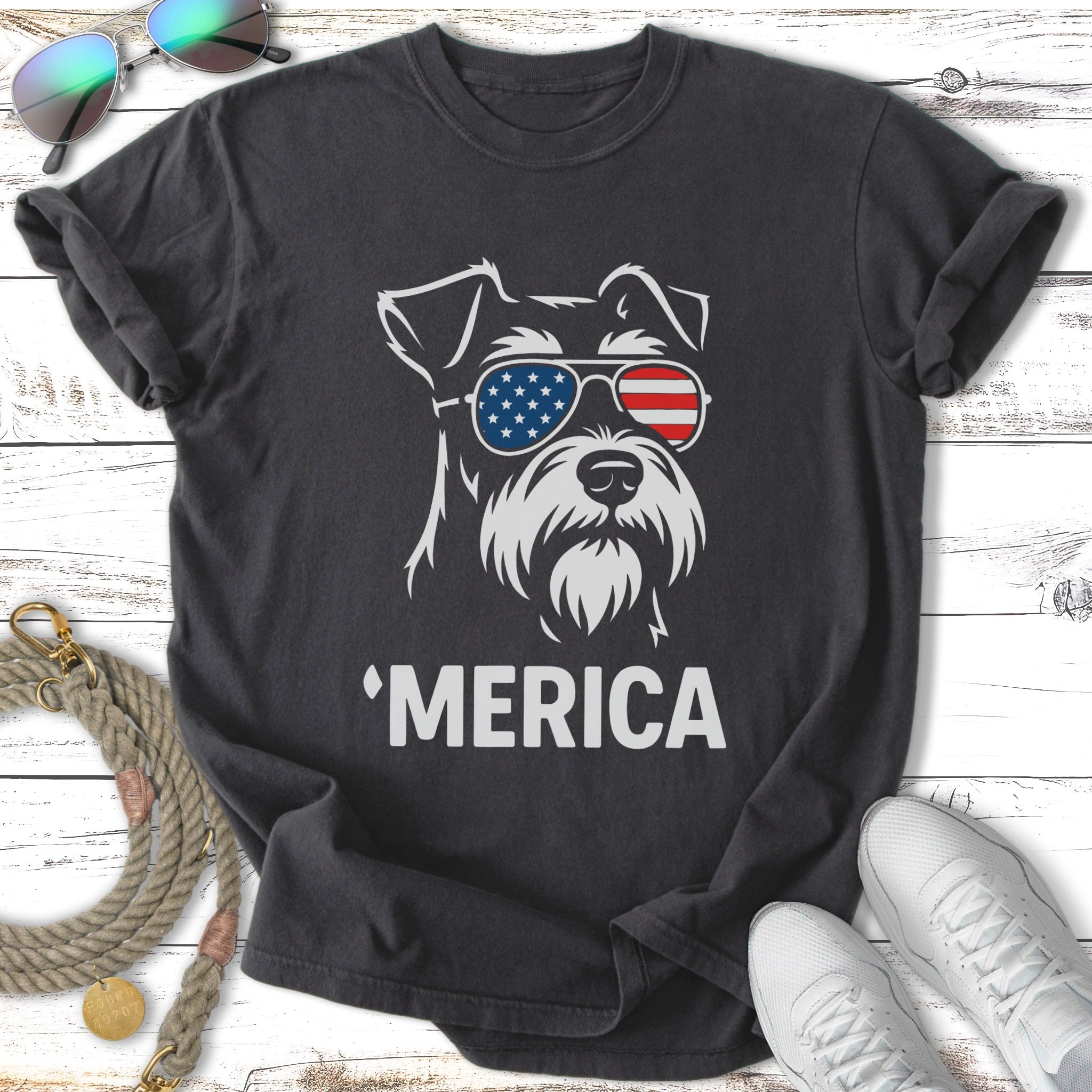 Dark t-shirt with white graphic of dog wearing American flag sunglasses and text 'MERICA.