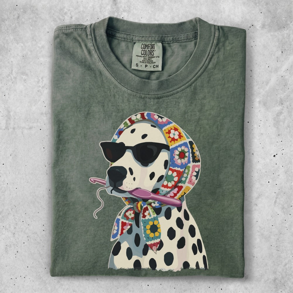 Dalmatian wearing sunglasses and a crochet scarf, holding a crochet hook.