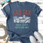 Blue t-shirt with "LAB TAX SNACK SAFETY INSPECTION UNIT" text and food graphics.