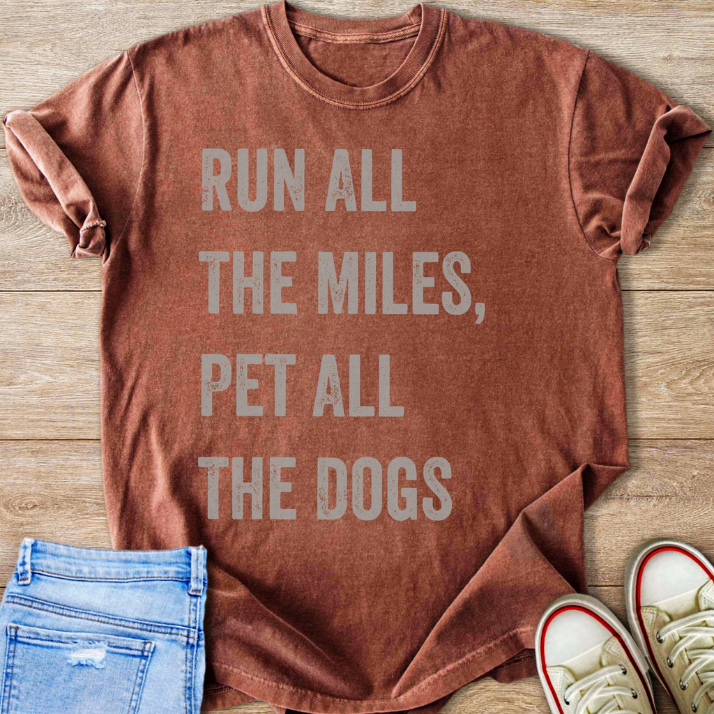 Brown t-shirt with text "RUN ALL THE MILES, PET ALL THE DOGS".