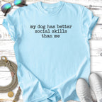 Light blue t-shirt with "my dog has better social skills than me" text.