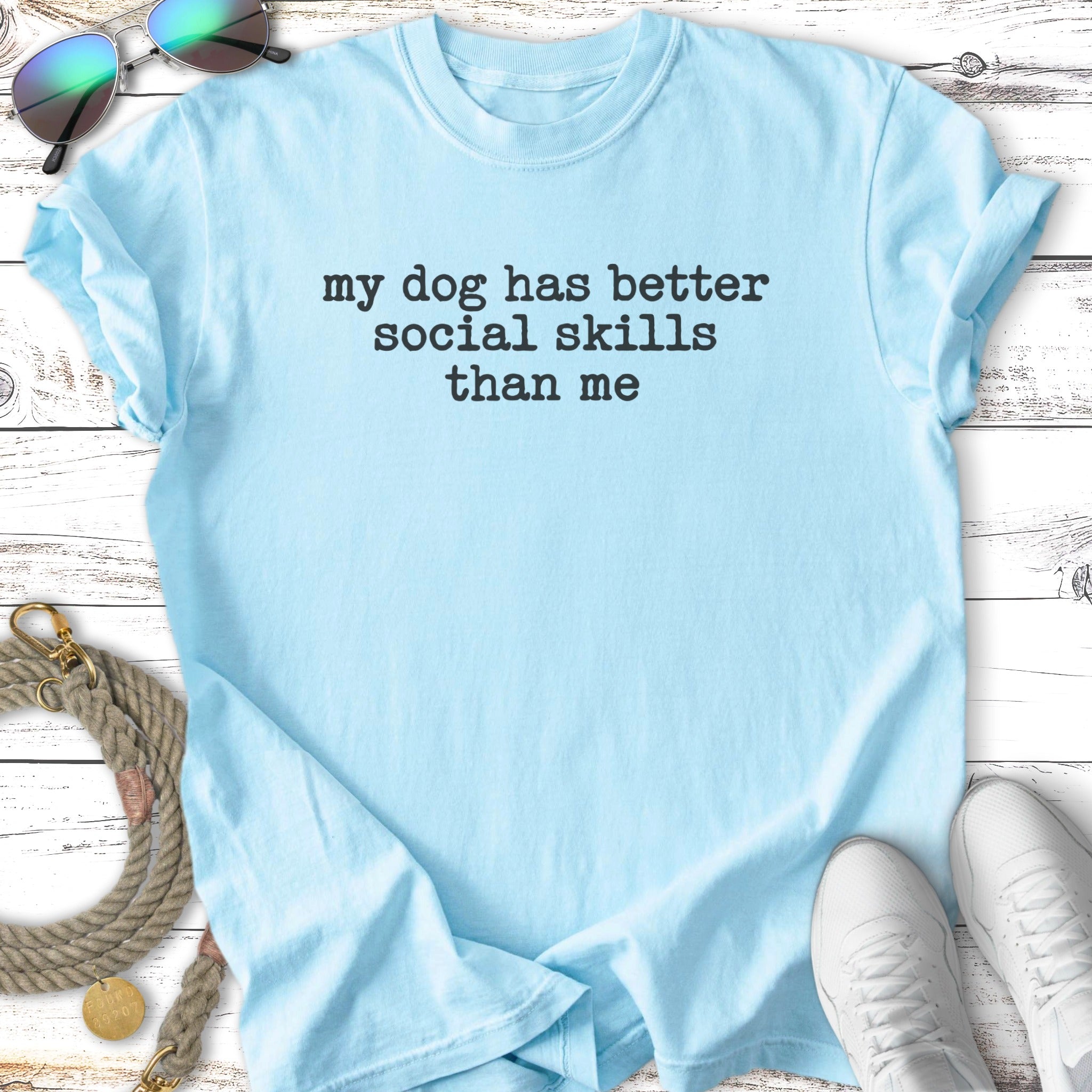 Light blue t-shirt with "my dog has better social skills than me" text.