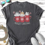 Three kittens in red mugs with candy canes and snowflakes, text says "MEOWLY CHRISTMAS."