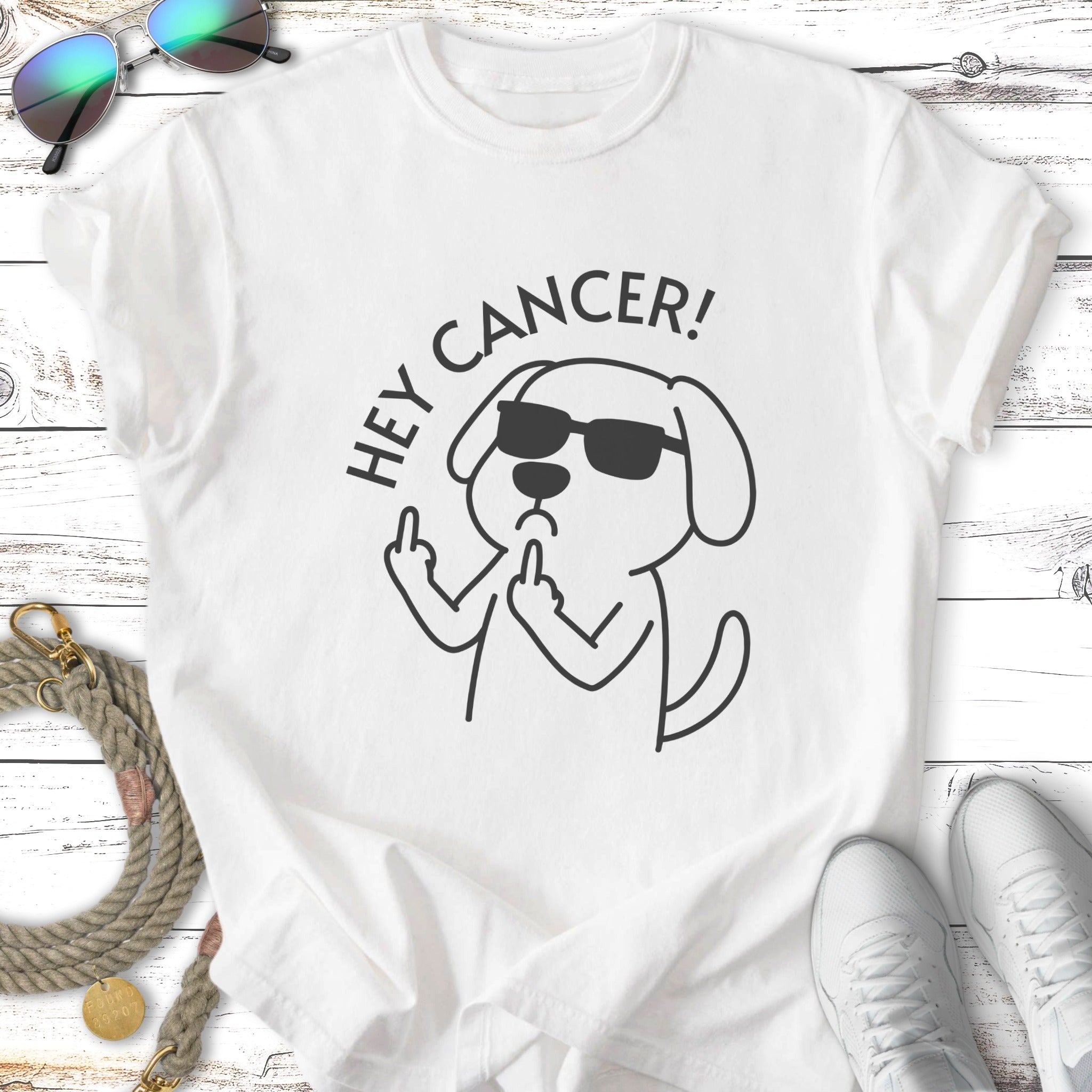 Cartoon dog wearing sunglasses flipping off cancer on a t-shirt.