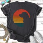 Dark t-shirt with dog silhouette against a retro sunset graphic.