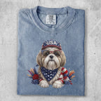 Dog wearing sunglasses and a USA bandana, with patriotic decorations.