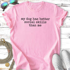 Pink t-shirt with "my dog has better social skills than me" text.