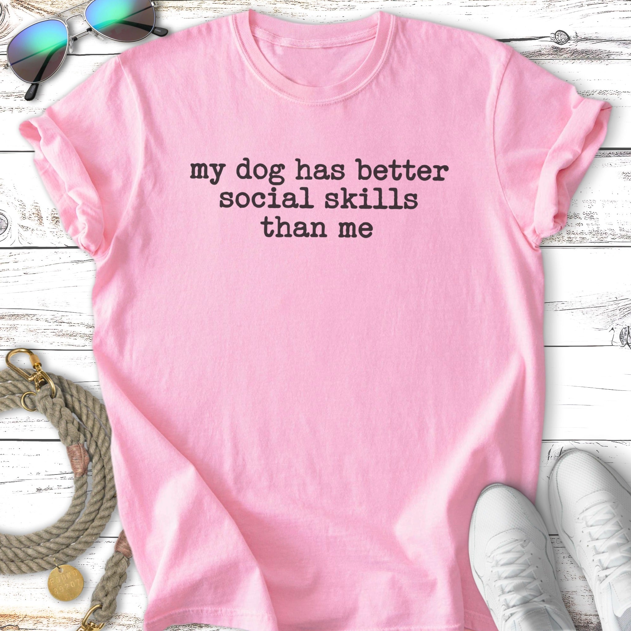 Pink t-shirt with "my dog has better social skills than me" text.