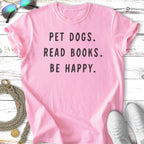 Pink t-shirt with black text "PET DOGS. READ BOOKS. BE HAPPY."