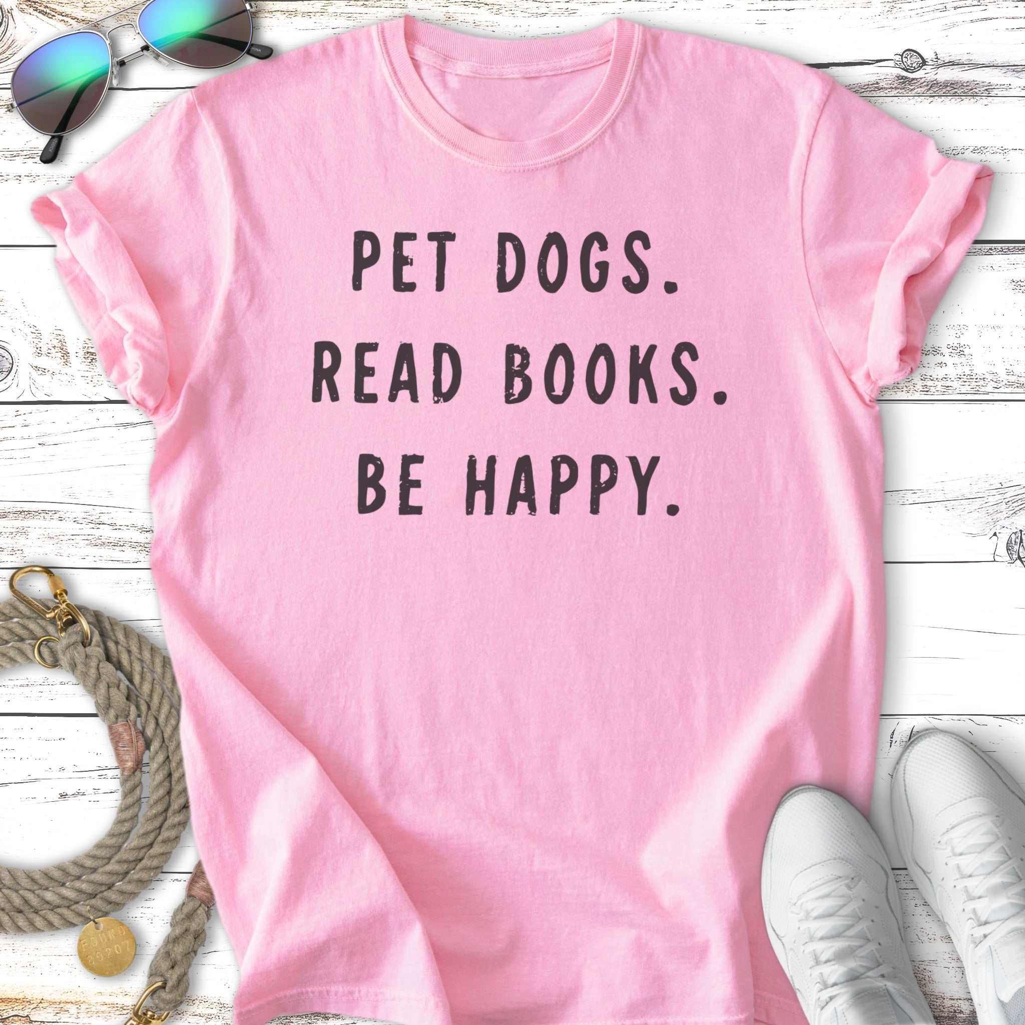 Pink t-shirt with black text "PET DOGS. READ BOOKS. BE HAPPY."