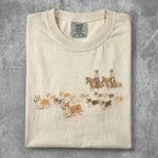 Cream t-shirt with print of corgis and cowboys riding horses.