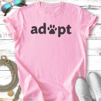 Pink t-shirt with "adopt" and a paw print in black text.