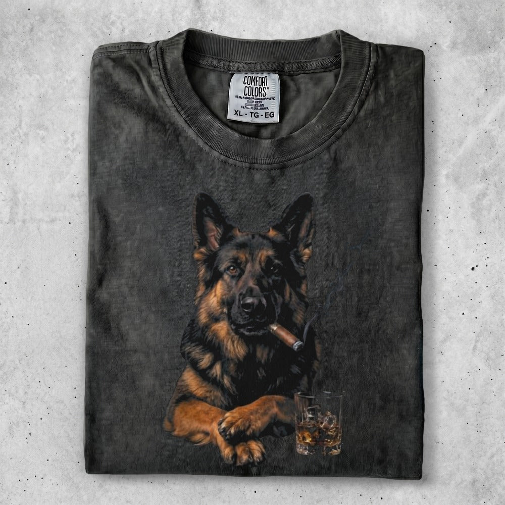 German Shepherd wearing a collar, smoking a cigar, sitting by a glass of whiskey.