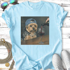 Yorkshire terrier wearing a blue cap, being poured red wine into a glass.