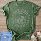 Green t-shirt with text "Fur Dad The Man The Myth The Snack Dealer" and paw prints.
