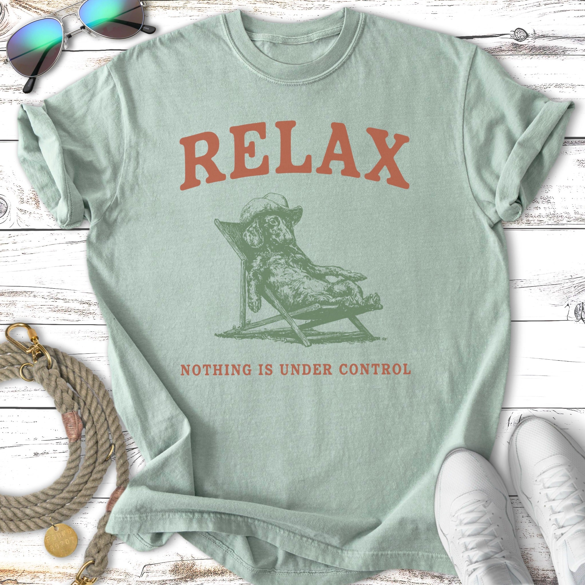 Light green t-shirt with dog relaxing in a chair, "RELAX NOTHING IS UNDER CONTROL" text.