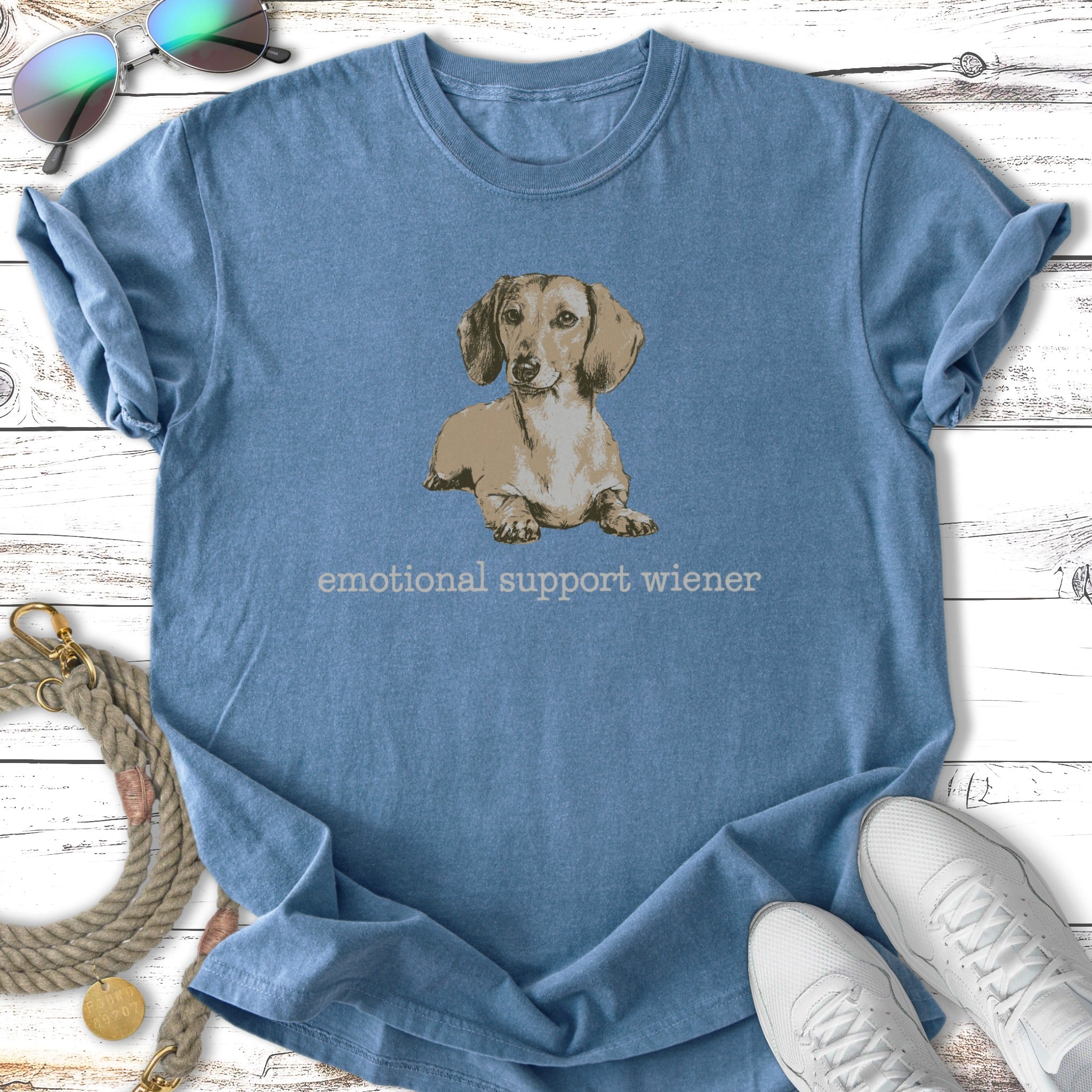 Blue t-shirt with a drawing of a dachshund and text "emotional support wiener".