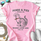 Pink t-shirt with "Purrs & Pies Pizza Co." and cat graphic.