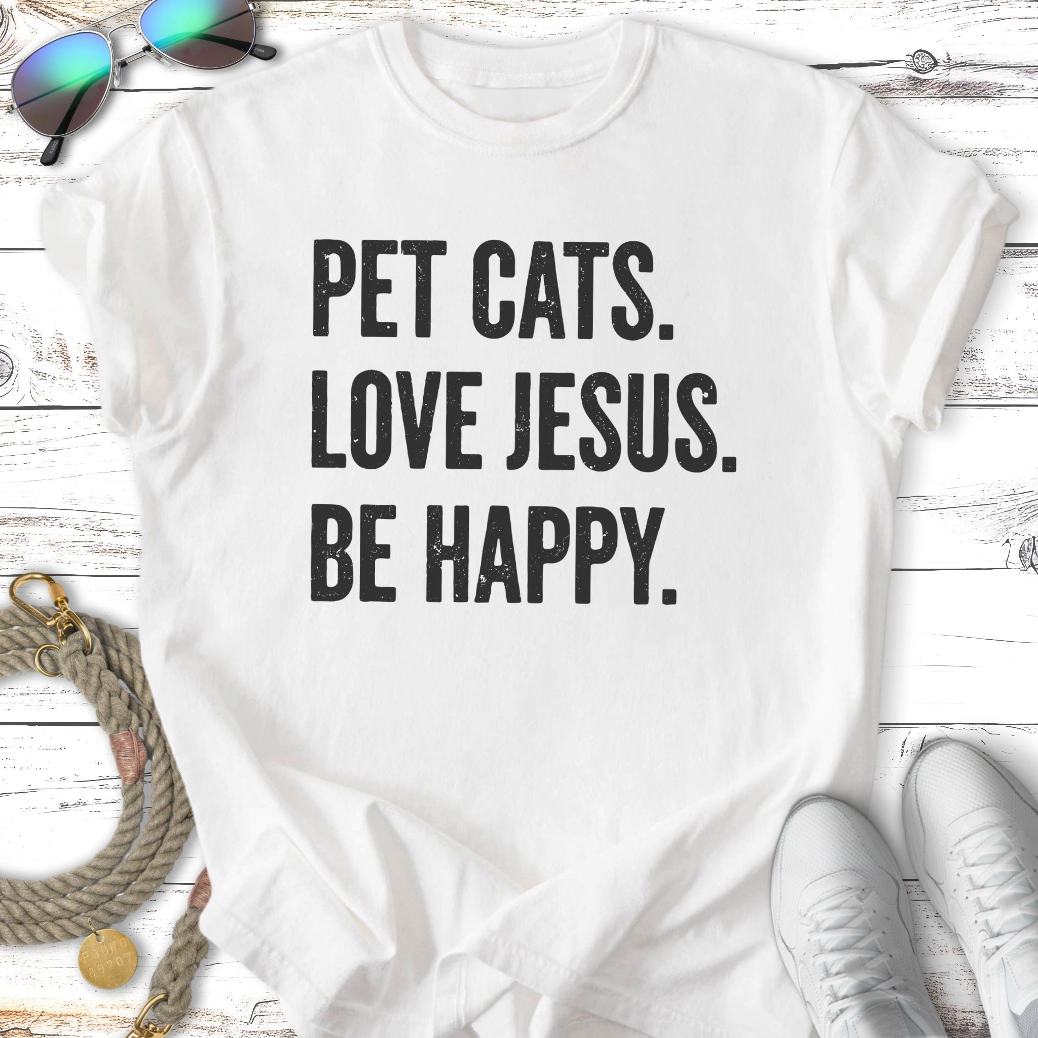 White t-shirt with text "PET CATS. LOVE JESUS. BE HAPPY."