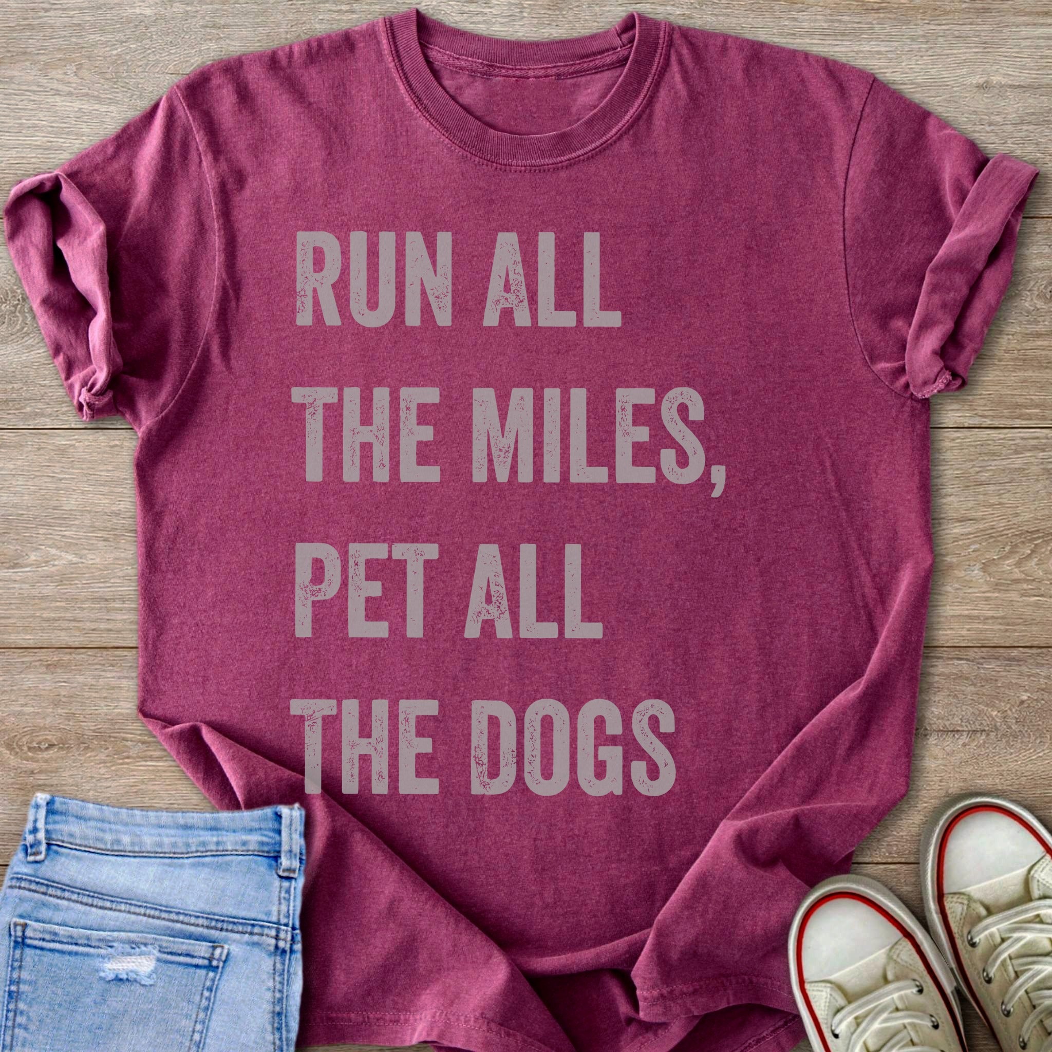 Maroon t-shirt with faded gray text "RUN ALL THE MILES, PET ALL THE DOGS".