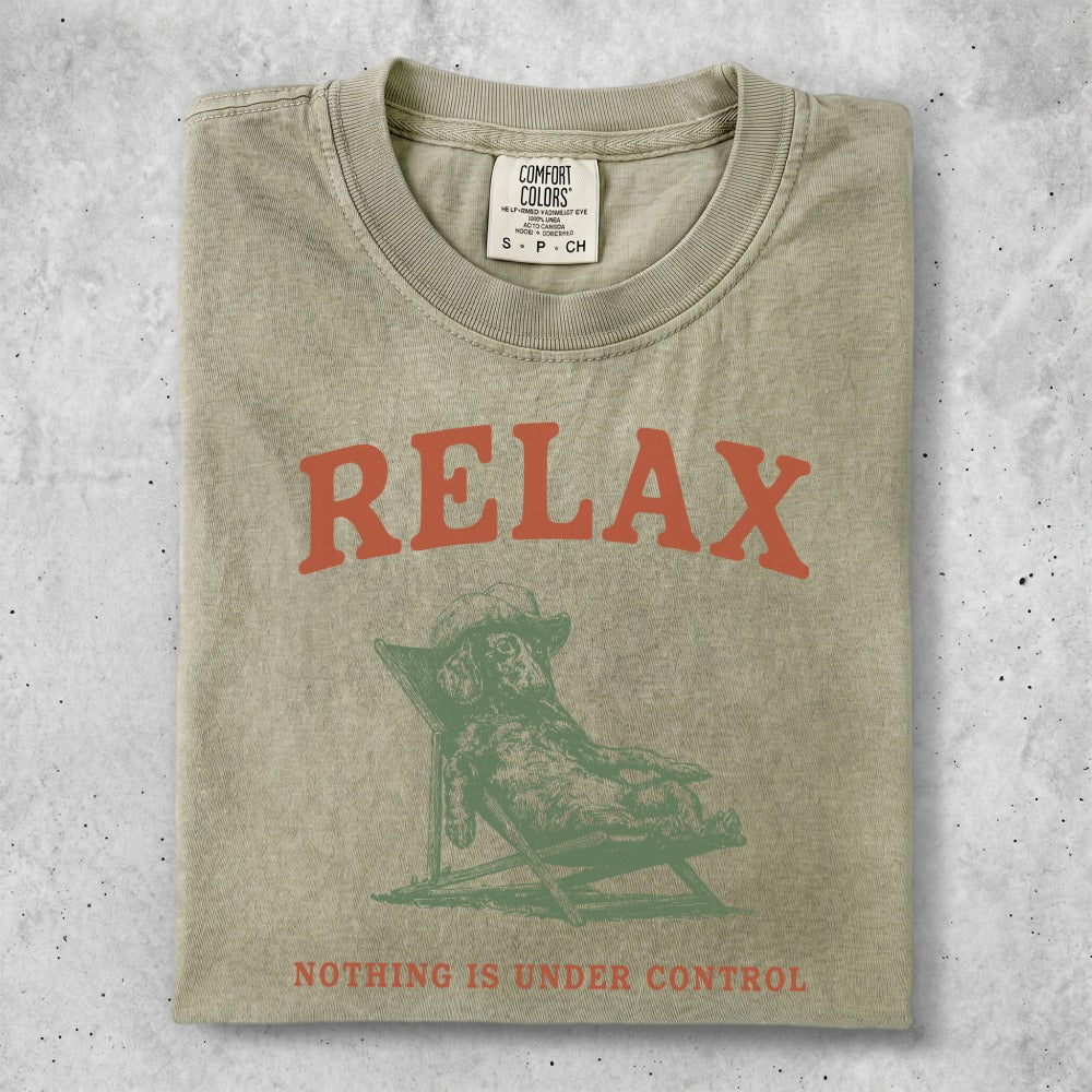 T-shirt with a graphic of a dog lounging in a chair and the text "RELAX NOTHING IS UNDER CONTROL".