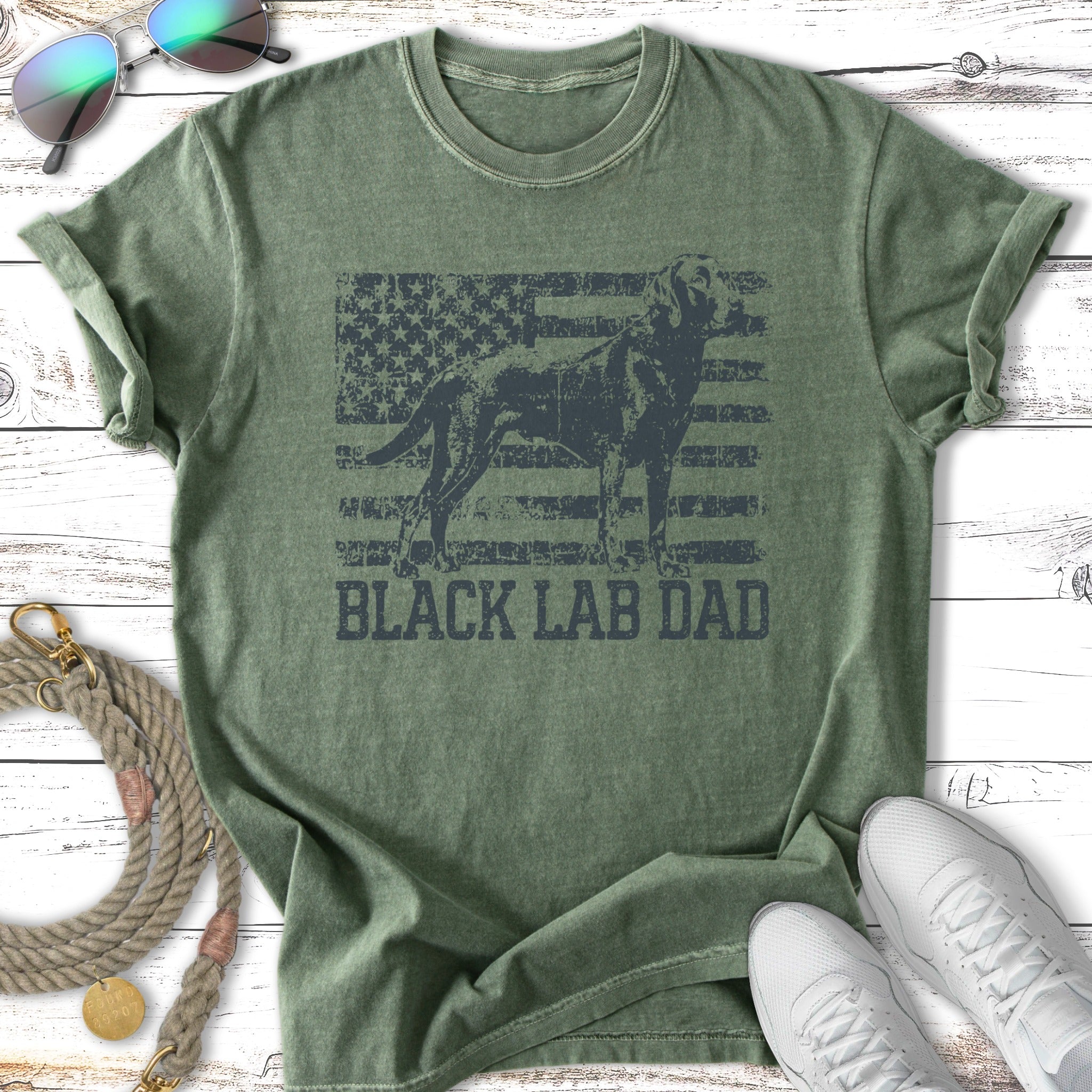 Black lab silhouette against American flag, text "BLACK LAB DAD" on green t-shirt.
