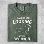 Green t-shirt with white text "I CAUGHT YOU LOOKING AT MY WEINER" and dachshund graphic.