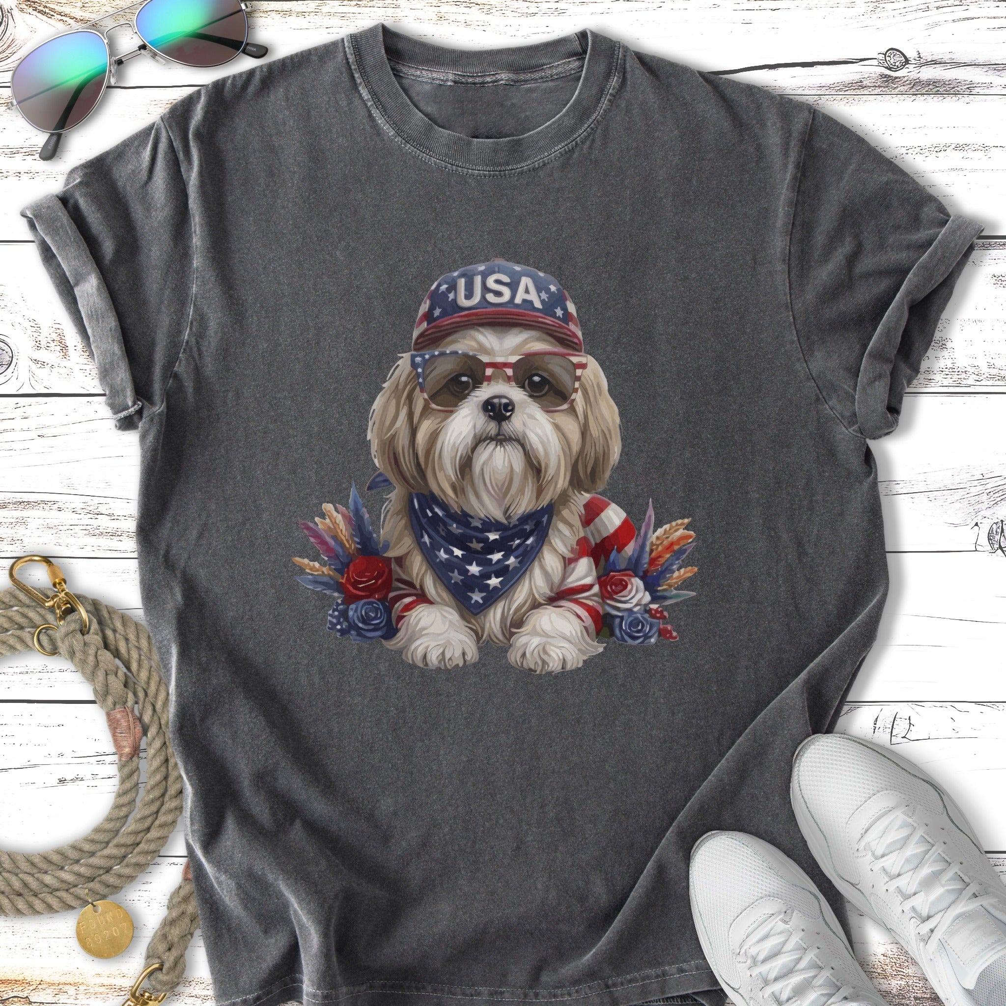 Dog wearing USA bandana and sunglasses with patriotic decorations.