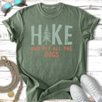 Green t-shirt with "HIKE AND PET ALL THE DOGS" text and a pine tree graphic.
