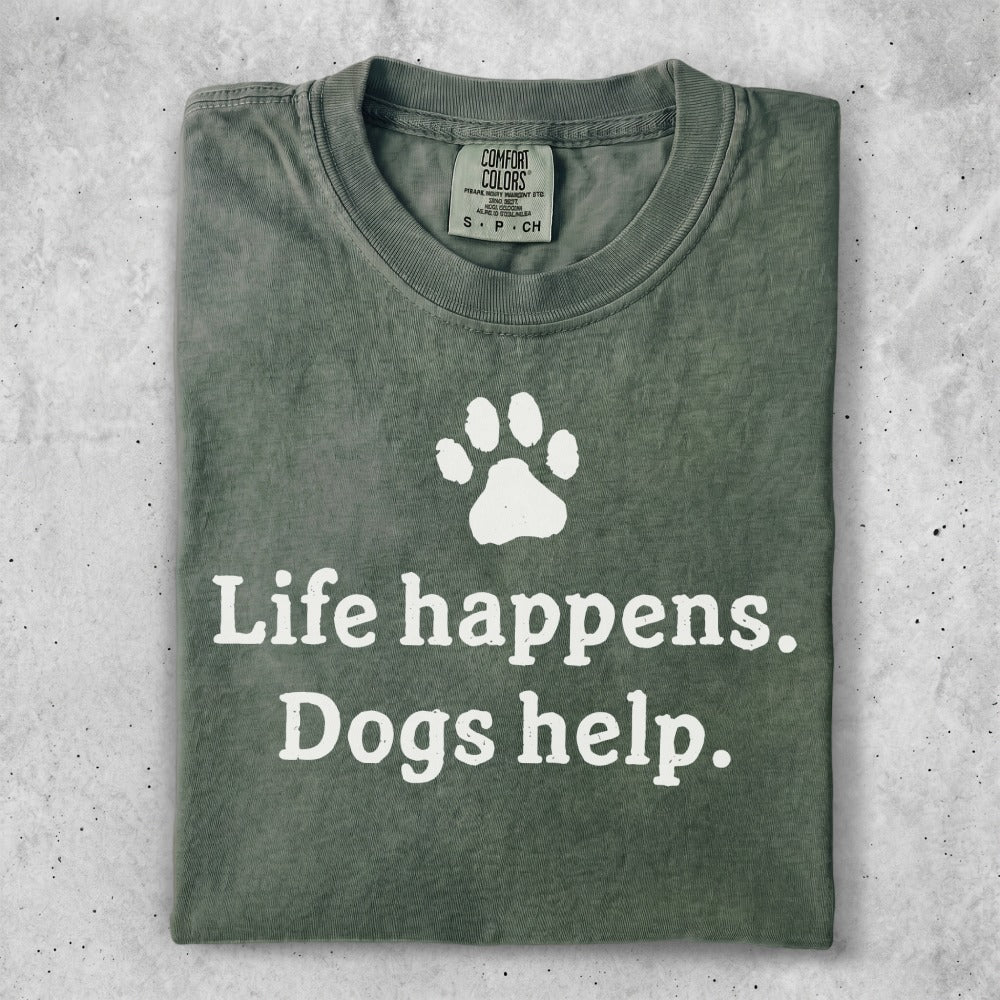 Olive green t-shirt with white paw print and text "Life happens. Dogs help."