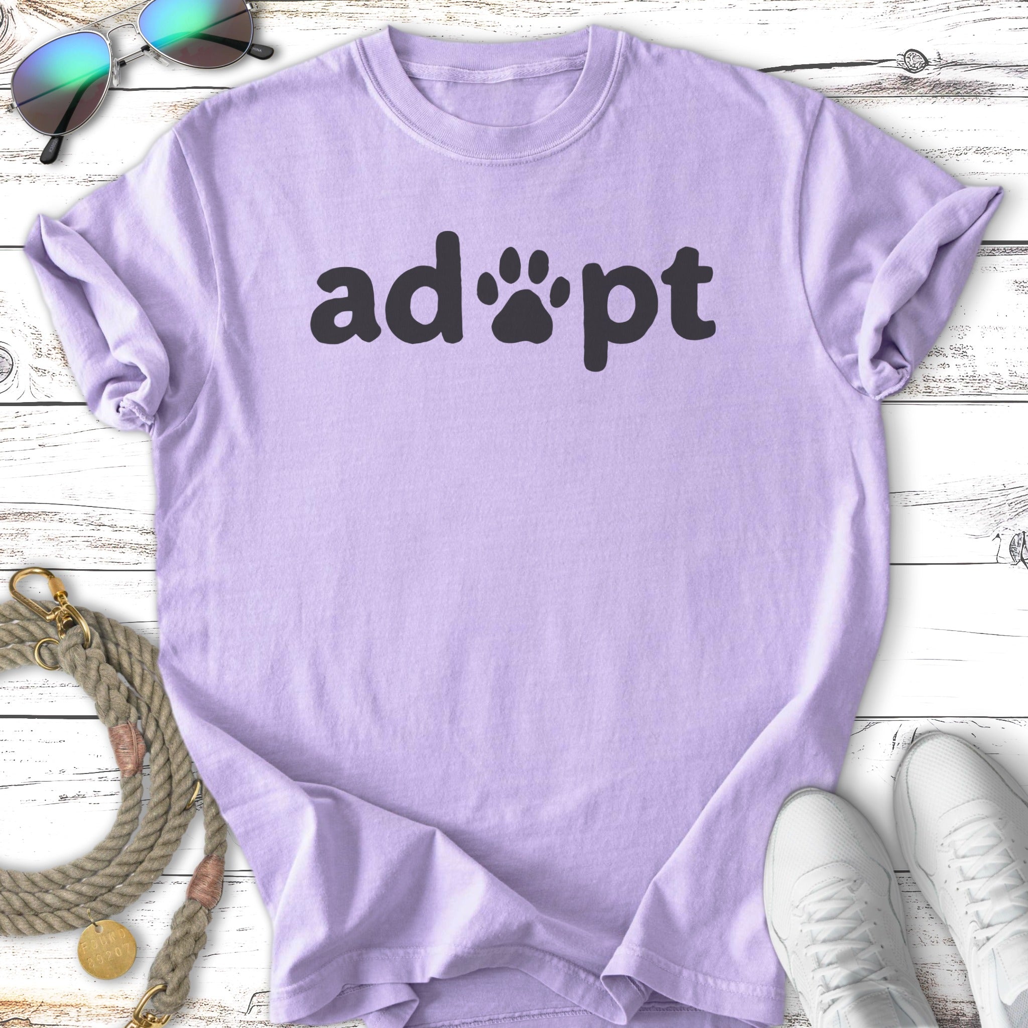 Lavender t-shirt with "adopt" in black text and paw print.