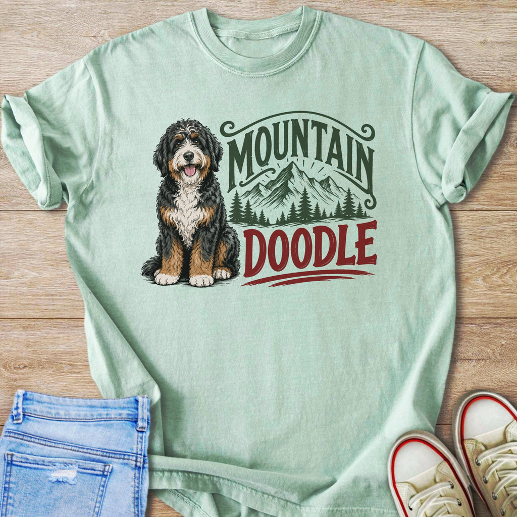 Mint green t-shirt with a doodle and mountain graphic.