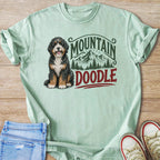 Mint green t-shirt with a doodle and mountain graphic.