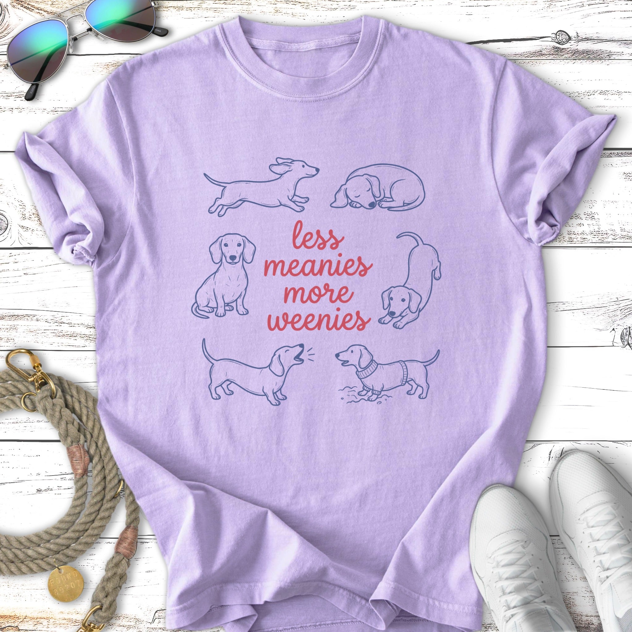 Light purple t-shirt with line drawings of dachshunds and text "less meanies more weenies".