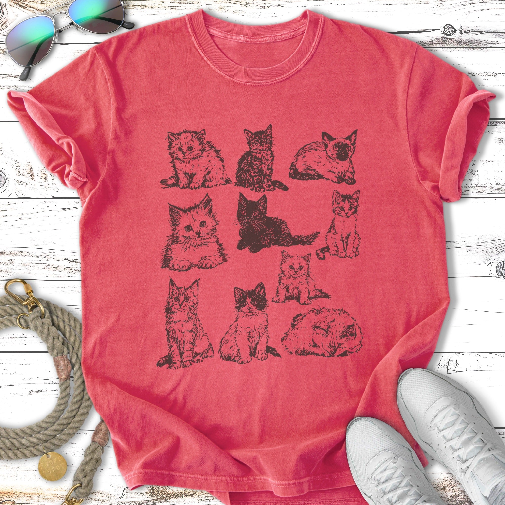 T-shirt with an illustration of nine different cats in varying poses.