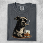 Dog in sunglasses smoking a cigar with a glass of whiskey.