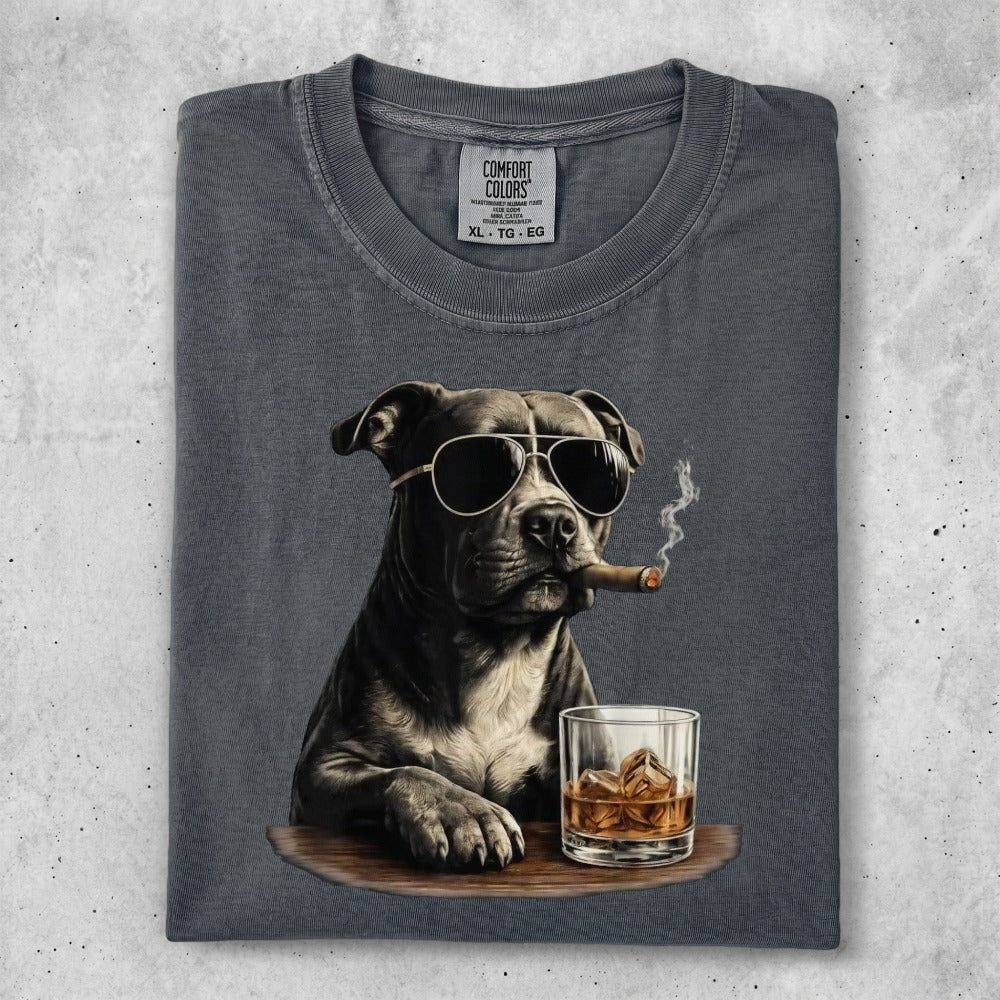Dog in sunglasses smoking a cigar with a glass of whiskey.