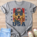 Golden retriever wearing American flag sunglasses and bandana, with "USA" text.