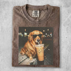 Golden retriever wearing sunglasses drinks iced coffee.