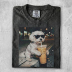 White dog in sunglasses drinks iced coffee from a plastic cup.