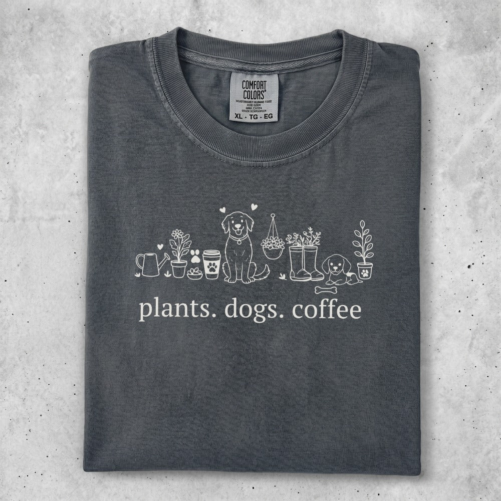 Dark gray t-shirt with white line art of plants, dogs, and coffee cups.