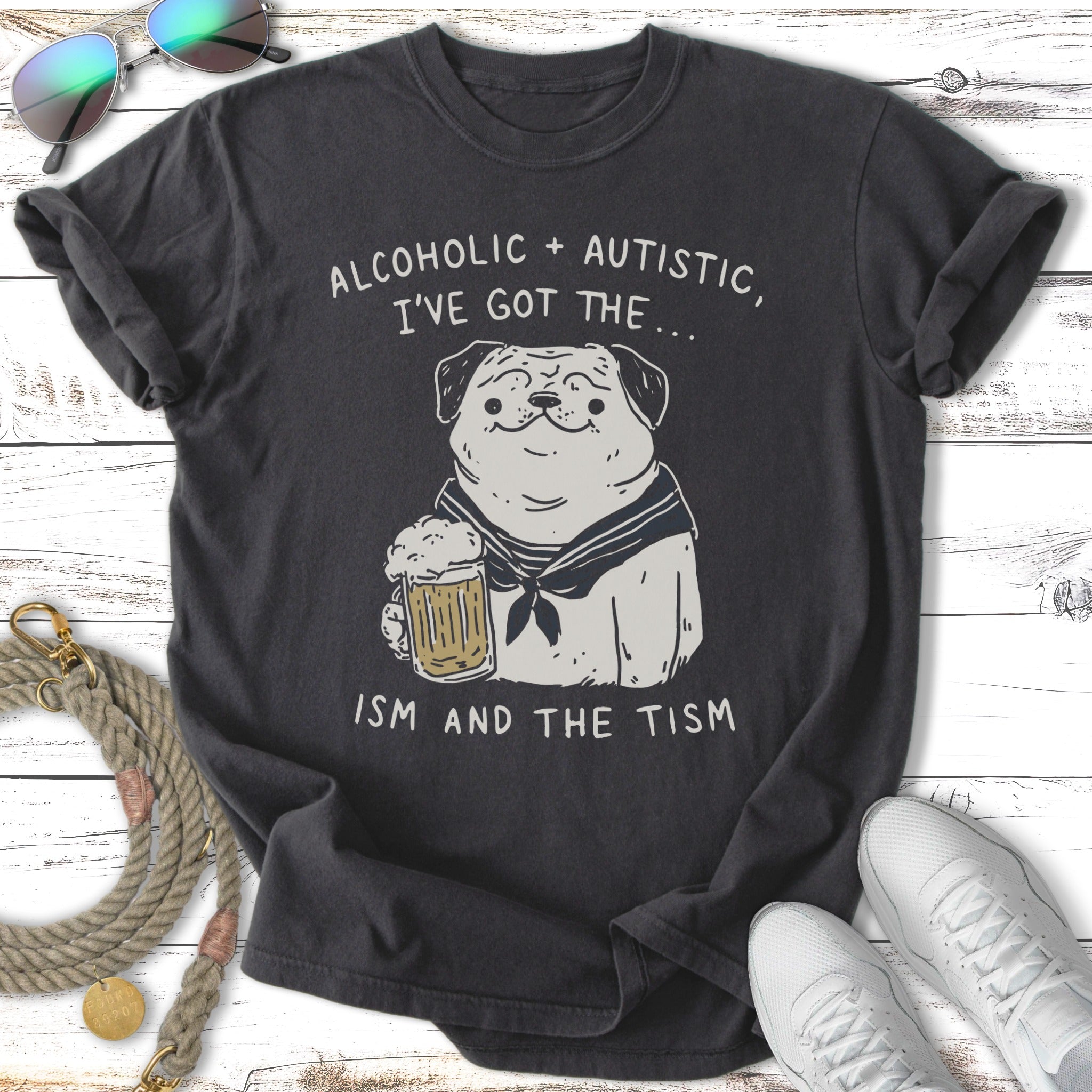 Dark t-shirt with pug wearing sailor collar holding a beer, text says "Alcoholic + Autistic, I've Got the... ISM AND THE TISM".