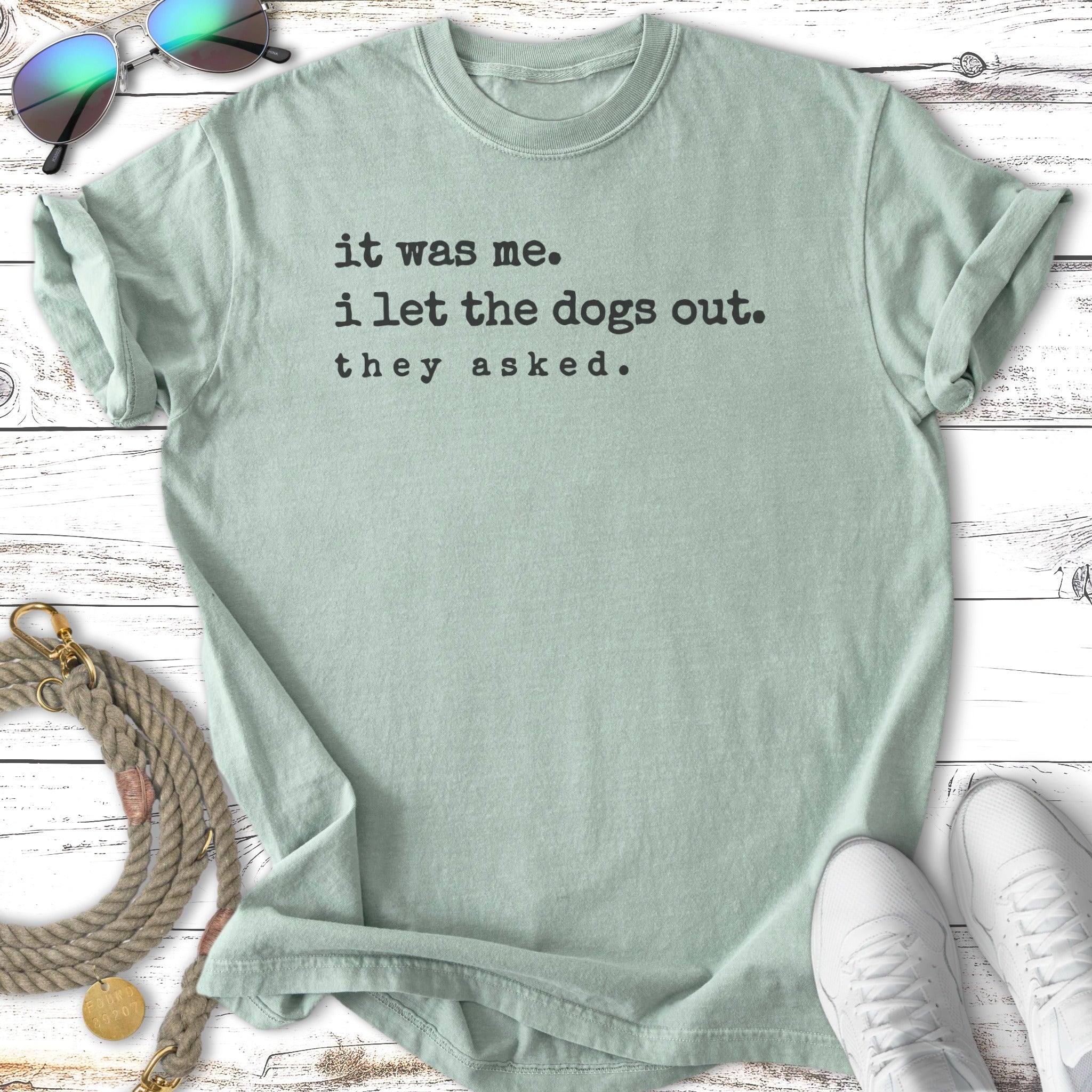 Light green t-shirt with black text: "it was me. i let the dogs out. they asked."