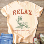 Peach t-shirt with "RELAX" graphic of a dog in a hat on a chair.