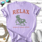 Purple t-shirt with "RELAX" and a dog in a hat relaxing in a chair.
